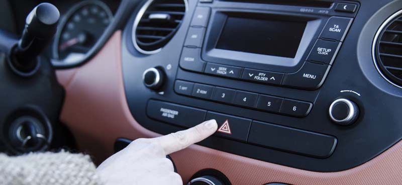 Photo of woman turning on hazard flashers in car